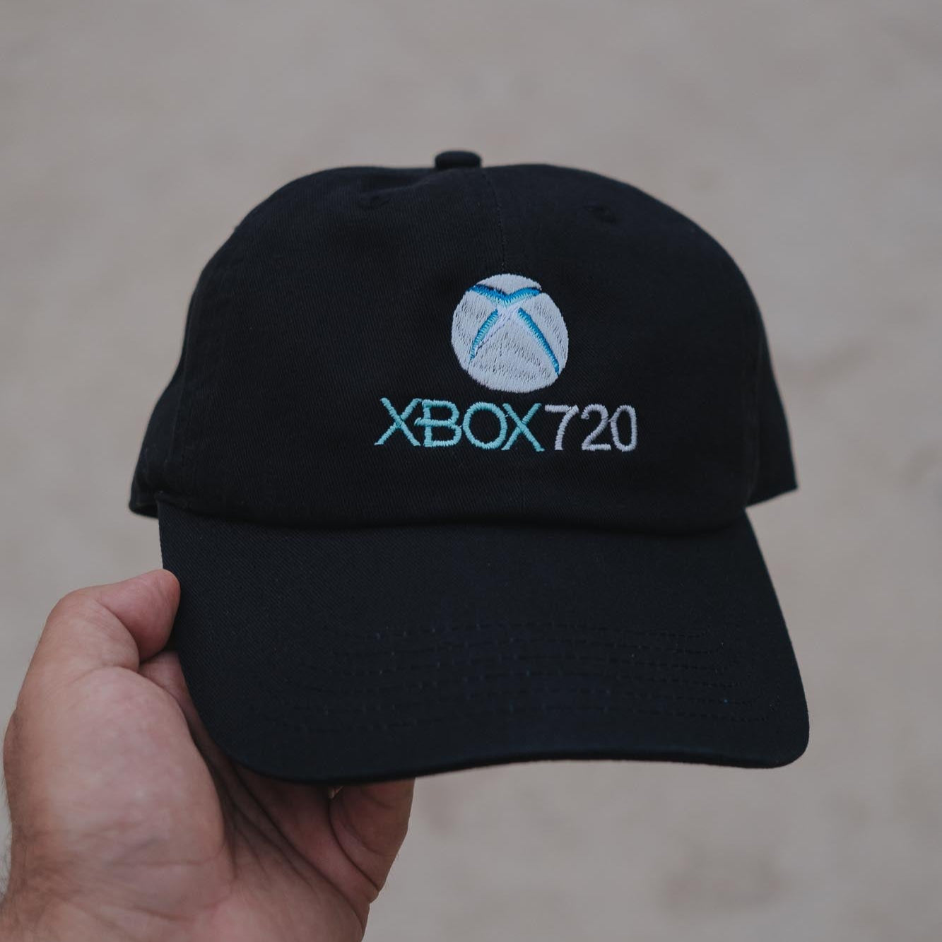 A black embroidered dad hat with the text 'XBOX720' and a logo on the front.