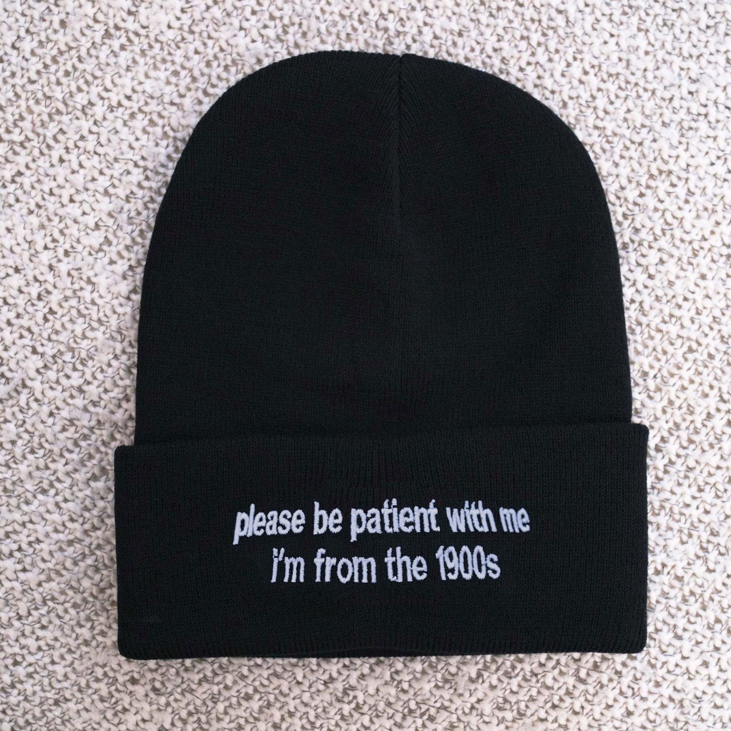 May include: Black beanie with white embroidered text that reads "please be patient with me I'm from the 1900s"